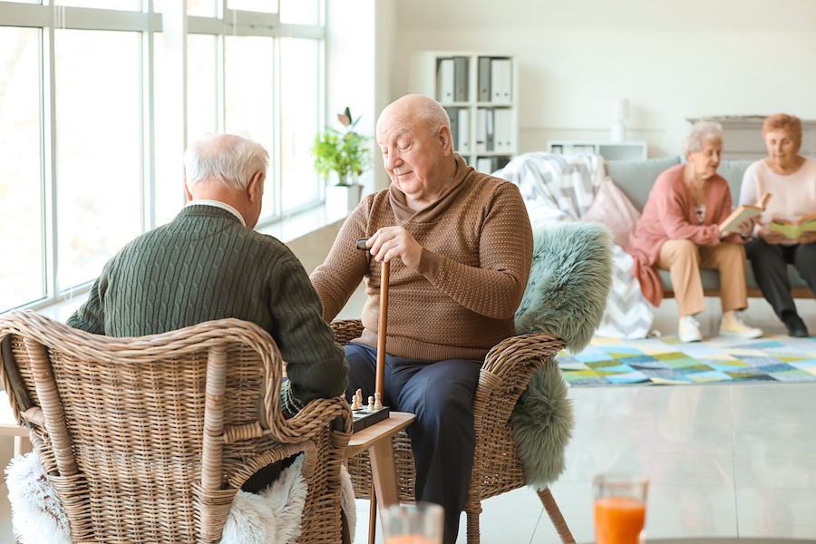 Senior men playing chess in nursing home Senior men playing chess in nursing home