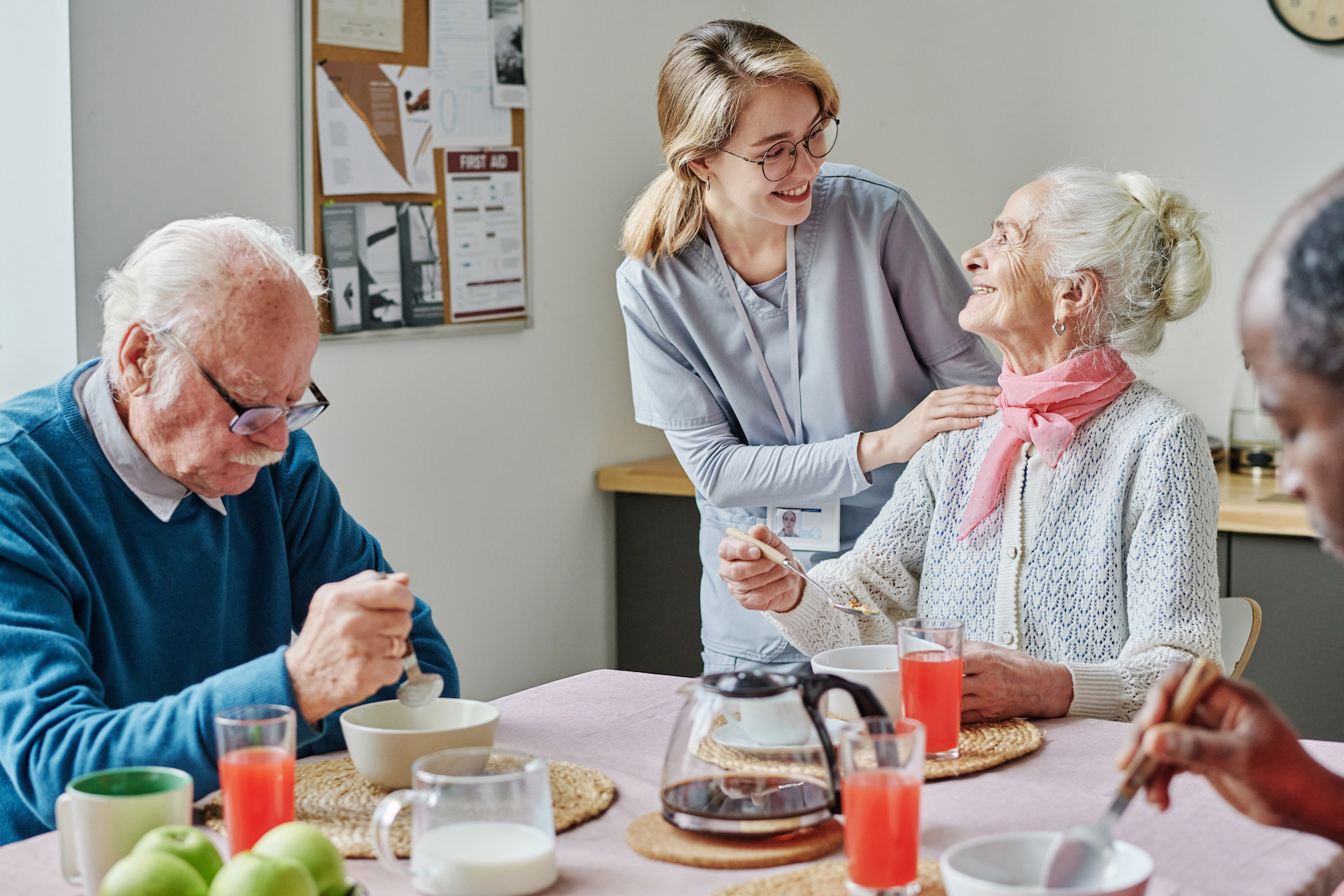 Caregiver helping senior people during lunch Caregiver helping senior people during lunch